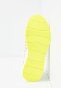 Semelle jaune vif d'une chaussure blanche affichant le nom de la marque "ESPRIT" et la pointure "37" avec un motif antidérapant texturé.