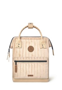 Beige gesteppter Rucksack mit Lederakzenten, Tragegriff oben, Reißverschlussfach vorne und rundem Logo, mit einer strukturierten Oberfläche und kontrastierendem Reißverschluss.