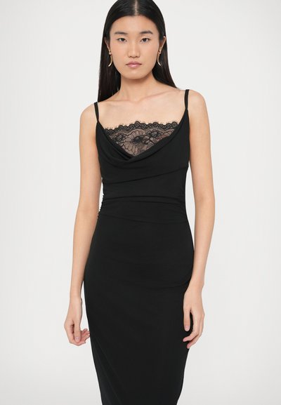 Čierne šaty s riaseným výstrihom a čipkovým lemom. Majú tenké ramienka, priliehavý strih a hladkú textúru.
