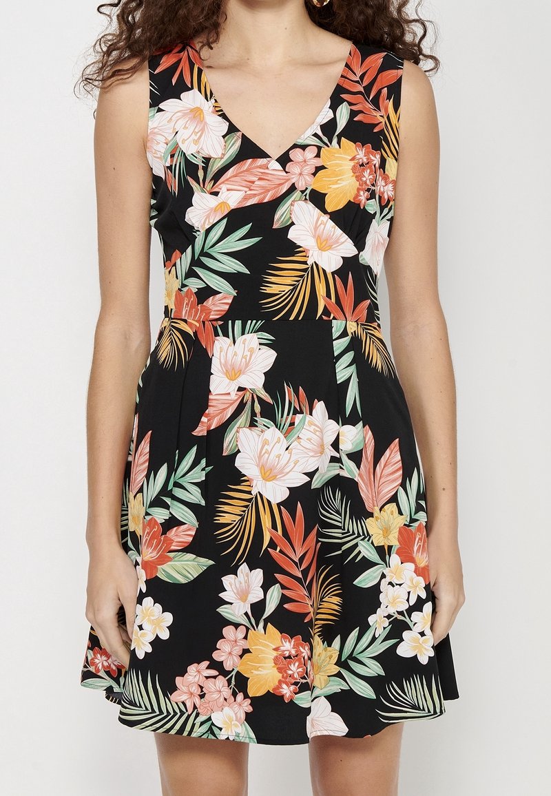 Vestido floral con escote en V, fondo negro, flores vibrantes en rosa, naranja y verde, con un cuerpo ajustado y falda acampanada.