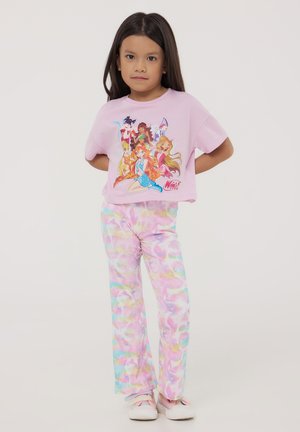 T-shirt cropped rosa chiaro con una grafica di cartoni animati colorata; pantaloni a zampa di elefante in tinta unita pastello con sfumature di rosa, blu e giallo; sneakers casual.