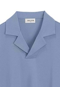 Polo bleu clair avec un col en V et un col rabattu. Fabriqué en tissu doux et respirant, il présente des détails de surpiqûres minimaux.