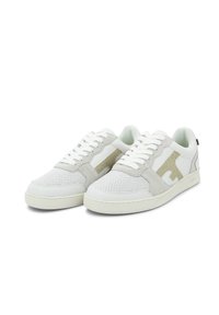 Weiße Sneakers mit grauen Wildlederakzenten und Mesh-Details, ausgestattet mit einem subtilen glitzernden Logo an der Seite und flachen Schnürsenkeln.