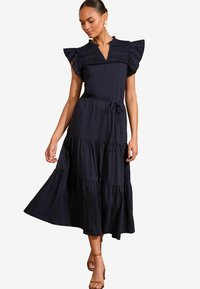 Rochie maxi de culoare bleu marin, cu volane la mâneci și detalii de dantelă croșetată la piept. Dispune de un talie cu cordon și o fustă vaporoasă.