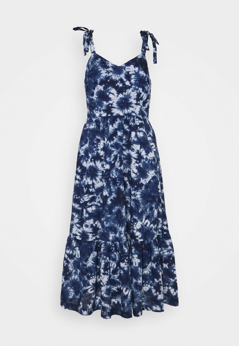 Robe d'été tie-dye bleue et blanche avec bretelles spaghetti nouées en nœuds et jupe à volants froncée sous la taille.