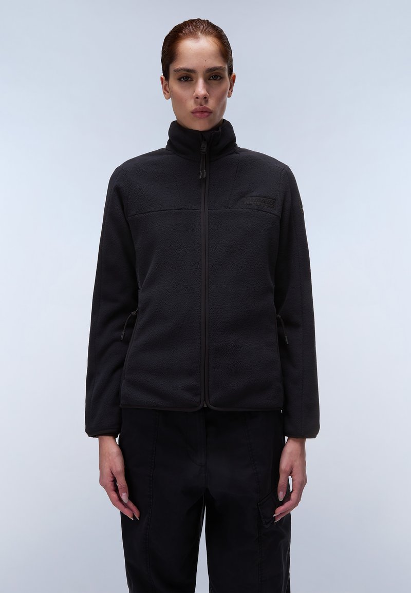 Giacca in pile nera con colletto alto, zip frontale, tasche laterali e rifiniture a contrasto. Include una patch con il logo sul petto.