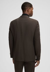 Brauner maßgeschneiderter Blazer mit strukturierter Oberfläche, schwarzem Kragen-Detail und geknöpften Ärmeln, Rückansicht.