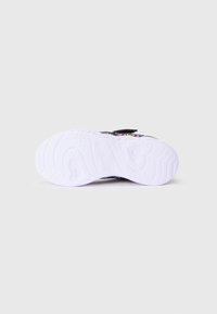 Skechers tenisice imaju gornji dio od crnog materijala sa šarenim cvjetnim uzorcima, čičak traku i strukturalnu bijelu gumenu potplatu.