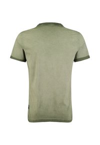 Camiseta corta de manga en color verde oliva liso, vista desde la parte posterior, con puños enrollados y una pequeña etiqueta negra cerca del dobladillo.