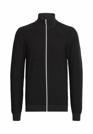 Cárdigan negro de punto con cremallera y cuello alto, que presenta puños y dobladillo acanalados, y una cremallera blanca. Patrón texturizado en toda la tela.