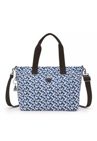 Blue and white patterned tote bag made of fabric, featuring brown handles, zip closure, and a decorative charm attached to a side.