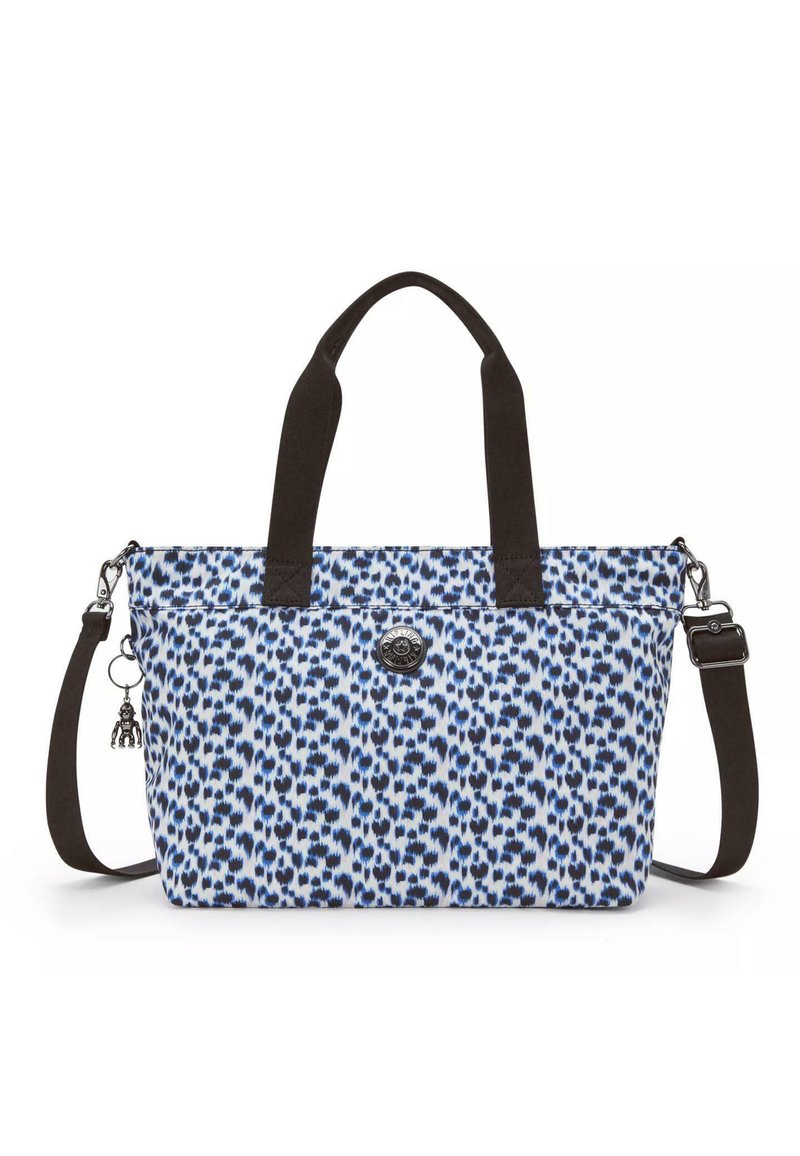 Blue and white patterned tote bag made of fabric, featuring brown handles, zip closure, and a decorative charm attached to a side.