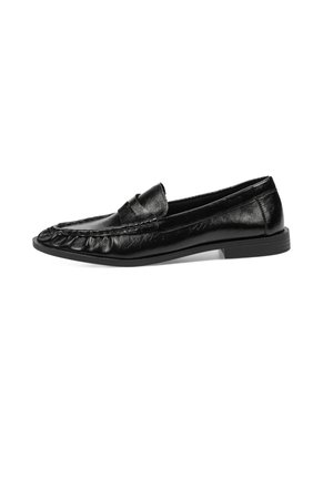 Mocasines de cuero negro con un acabado texturizado, que presentan un diseño cosido a lo largo de la punta y una suela plana de goma.