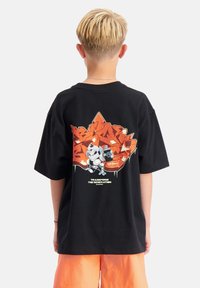 Zwart T-shirt met korte mouwen, voorzien van een kleurrijk graphic design van een blad en karakters op de achterkant, met een relaxte pasvorm en een gladde stof.