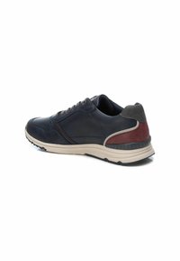 Sneaker blu navy con tomaia in pelle texturizzata, dettagli grigi, striscia rossa e suola in gomma color crema. Presenta un design con lacci e un colletto imbottito.