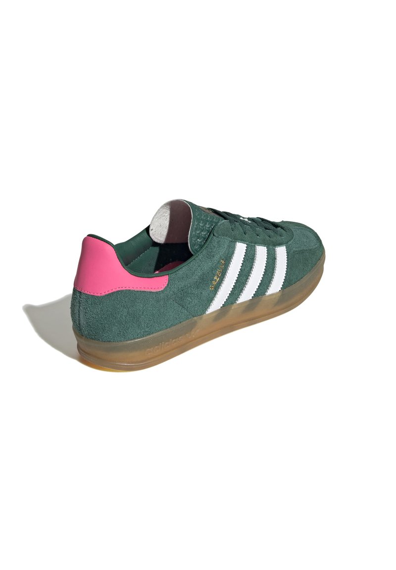 Sneaker verde in suede con strisce bianche, accentuazione rosa sul tallone, linguetta testurizzata e suola in gomma traslucida. Presenta lacci piatti e collare imbottito.