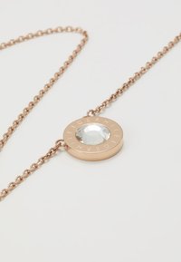 Necklace od ružičastog zlata s kružnim privjeskom s prozirnim fasetiranim dragim kamenom u središtu, ukrašenim brendiranjem oko ruba.