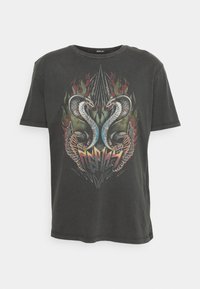 Camiseta de algodón negra con un diseño gráfico que presenta dos serpientes, alas, llamas y acentos angulares. Cuello redondo y mangas cortas.