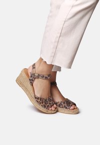 Sandály na platformě s leopardím potiskem, s texturovanou, přírodní jute podrážkou a nastavitelnými kotníkovými pásky. Design s otevřenou špičkou, s detailním zakováním.