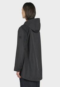 Giacca nera impermeabile con cappuccio, caratterizzata da una vestibilità comoda, tessuto testurizzato e una toppa con logo sulla manica sinistra.