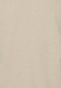 Béžová bavlněná tkanina, mírně texturovaná, s hladkým povrchem. Žádné výrazné vzory nebo designy nejsou viditelné, barva a vzhled jsou konzistentní.