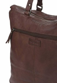 Bolso tote de cuero marrón con cremallera superior, bolsillo frontal con cremallera, asas dobles y parche de marca cosido.