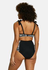 Maillot de bain deux pièces avec des textures noires et à motifs. Bretelles réglables avec nœuds ; bas taille haute avec un détail de motif sur les côtés.