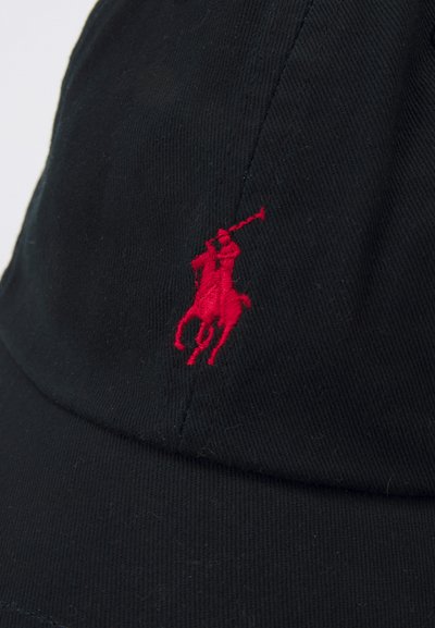 Casquette noire en coton, avec un logo de joueur de polo brodé en rouge sur le devant. Le design comprend une visière incurvée et un tissu texturé.