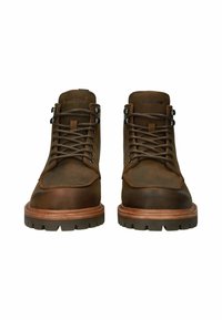 Botas de piel marrón con cordones y un cuello acolchado, que cuentan con ojales de metal y una suela resistente. Logotipo embosado en la lengüeta.