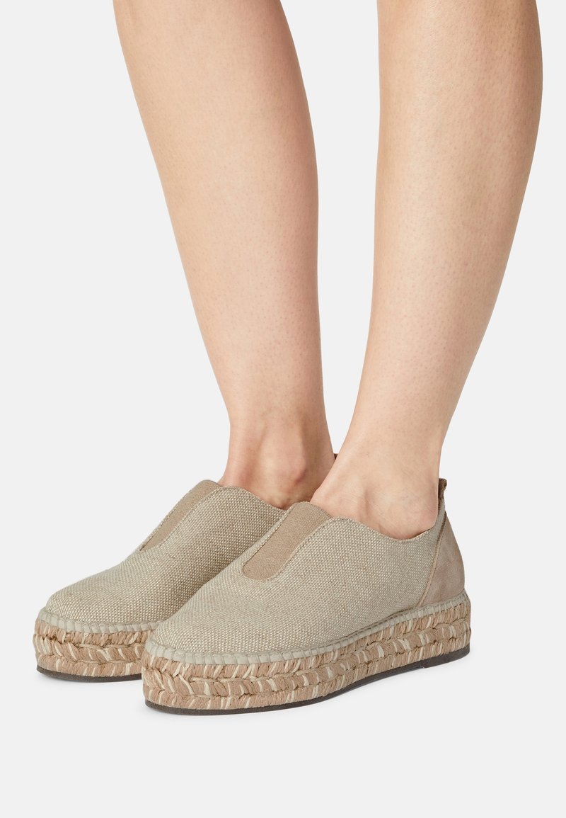 Chaussures espadrilles beiges à enfiler avec semelle tissée et panneau élastique, portées pieds nus, vues de côté et de face.