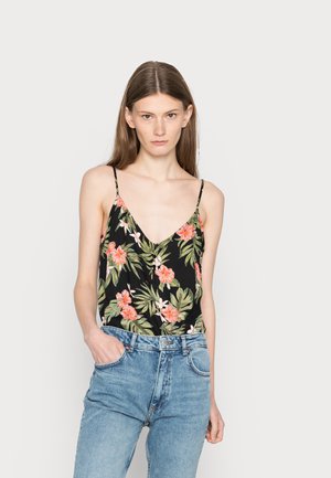 Top de manga larga preto com estampa floral, alças finas, apresenta uma impressão tropical em rosa e verde; combinado com jeans de cintura alta em azul claro.