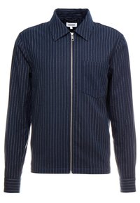 Chaqueta de rayas marinas confeccionada en tela, con cierre frontal de cremallera, cuello y un bolsillo en el pecho; presenta finas rayas blancas y mangas largas.