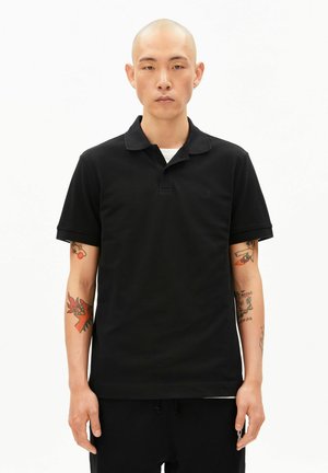 Schwarzes Poloshirt mit Kragen, kurzen Ärmeln und kleinem Logo auf der Brust. Aus strukturiertem Stoff gefertigt, mit geradem Saum.