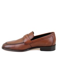Braune Lederloafers mit glatter Oberfläche, abgerundeter Zehenpartie, genähten Details und flachem, niedrigem Absatz. Mit einem Riemen an der Vorderseite akzentuiert.