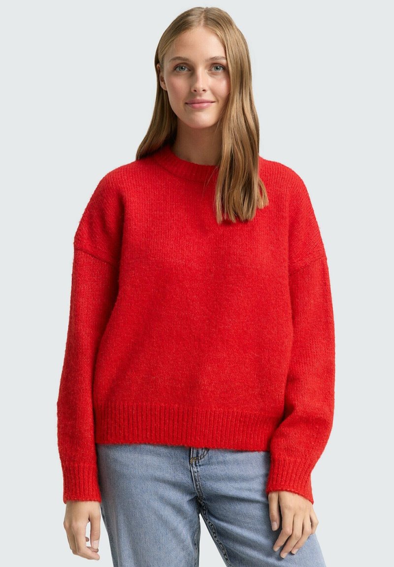 Czerwony sweter na drutach z okrągłym dekoltem, luźnym krojem i ściągaczami na mankietach. Miękka tekstura, jednolity kolor bez wzorów. Casualowy design.