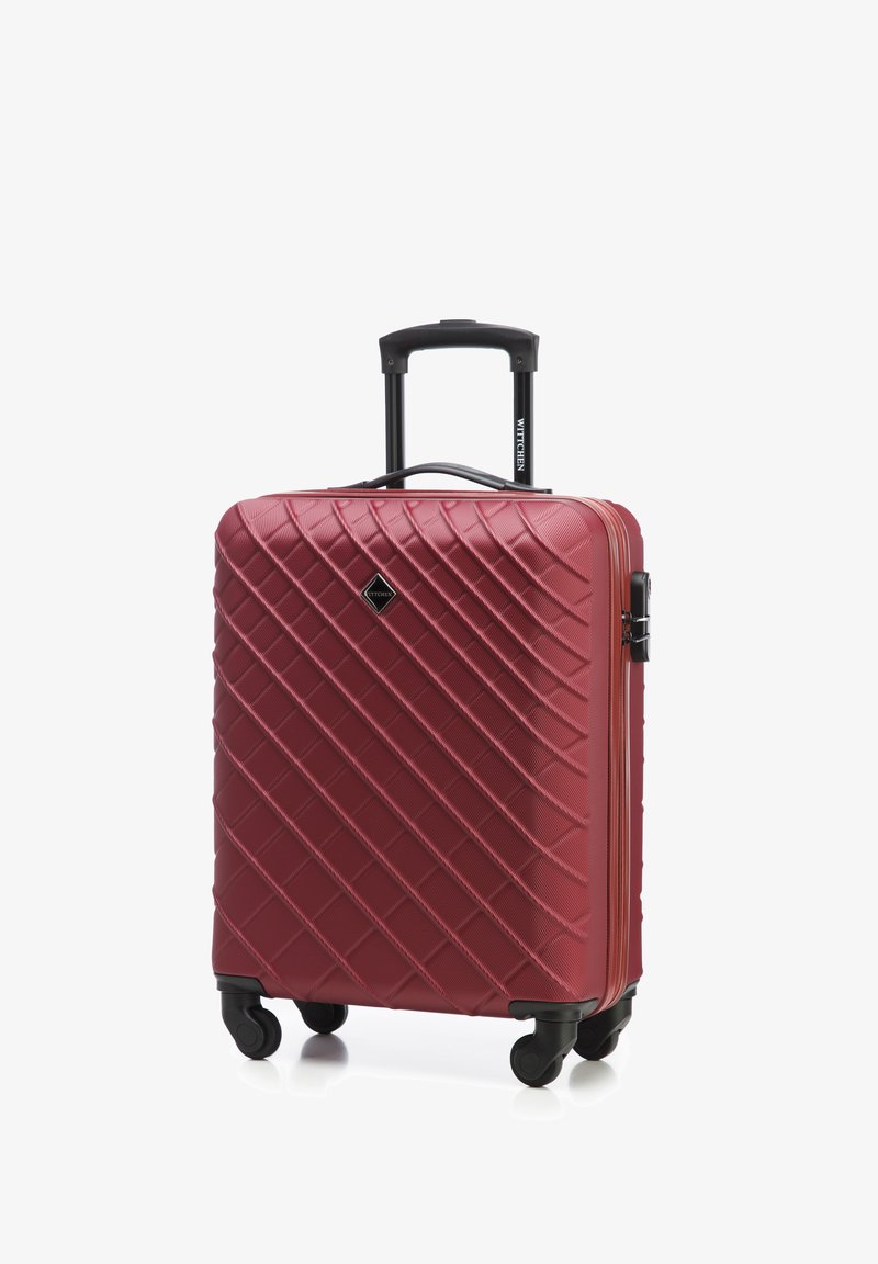 Czerwony twardy walizka z teksturą w diamentowy wzór, czarną teleskopową rączką i obrotowymi kółkami dla łatwego przemieszczania. Zamek błyskawiczny i szczegóły marki.