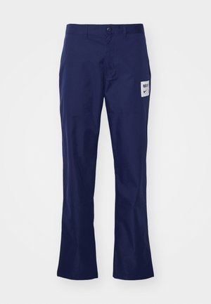 Hose aus navyblauem Baumwollstoff mit geradem Schnitt, ausgestattet mit einem Knopfverschluss und einem aufgenähten Logo auf der Vorderasche. Glatte Textur, lässiges Design.