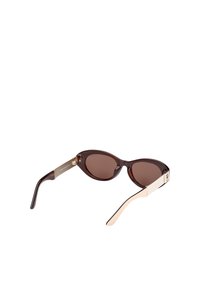 Brune katteøje-solbriller med en blank mørkebrun ramme, lyse cremefarvede detaljer på stængerne og tonede linser. Guldhardware-detaljer synlige.
