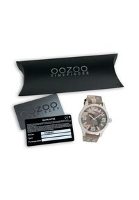 Montre OOZOO ronde avec un bracelet à motifs camouflage, un boîtier en argent et des marqueurs d'heure blancs. Comprend l'emballage et la carte de garantie.