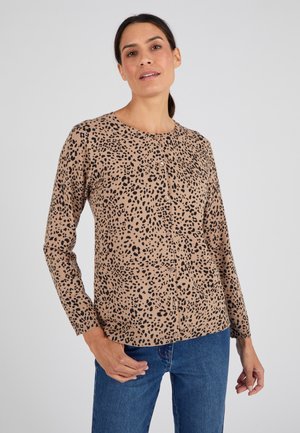 Chemise à manches longues beige avec un motif léopard, col rond et cinq boutons sur le devant. Tissu doux et coupe régulière.