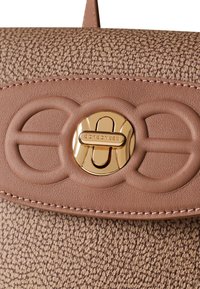 Beige structured handbag in textured material featuring a smooth leather flap, gold hardware with logo, and stitched accents.