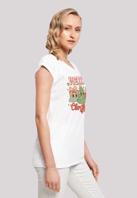 Weißes Baumwoll-T-Shirt mit kurzen Ärmeln, das ein farbenfrohes, weihnachtliches Motiv zeigt, einschließlich Bäume und festliche Akzente.
