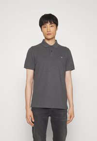 Kulgrå polo-shirt i bomuldsblanding, med en tre-knaps placket, korte ærmer og et diskret logo på venstre bryst.