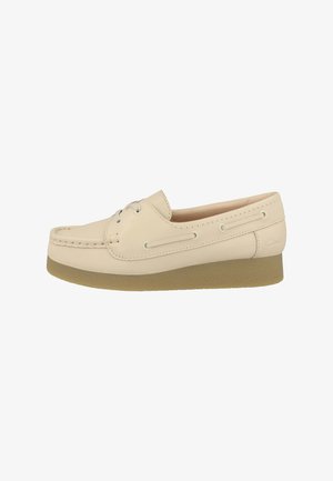 Mocassino beige in pelle con dettaglio in pizzo, punta mocassino e suola spessa e testurizzata, progettato per un uso casual.