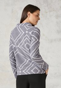 Grau gemusterter Pullover mit geometrischen Designs, aus strukturiertem Strickstoff gefertigt. Verfügt über einen hohen Kragen und lange Ärmel.