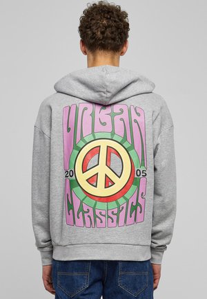 Grå hettegenser med store fargerike fredssymbol grafikk og teksten "URBAN CLASSICS 2005" på baksiden.