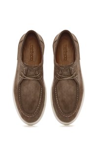 Scarpe casual in suede marrone con punta tonda, dettagli di cucitura e suola in gomma bianca. Presentano lacci e una soletta con marchio.