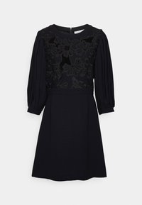 Černé šaty s texturovaným květinovým krajkovým korzetem, nafouknutými rukávy a přiléhavým pasem. Hladká látka s rozšířenou sukní. Zapínání na zip na zadní straně.