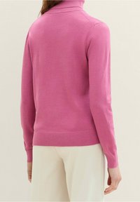 Różowy sweter typu golf wykona z miękkiej, gładkiej dzianiny, z dopasowanym krojem i prążkowanymi mankietami oraz dołem.