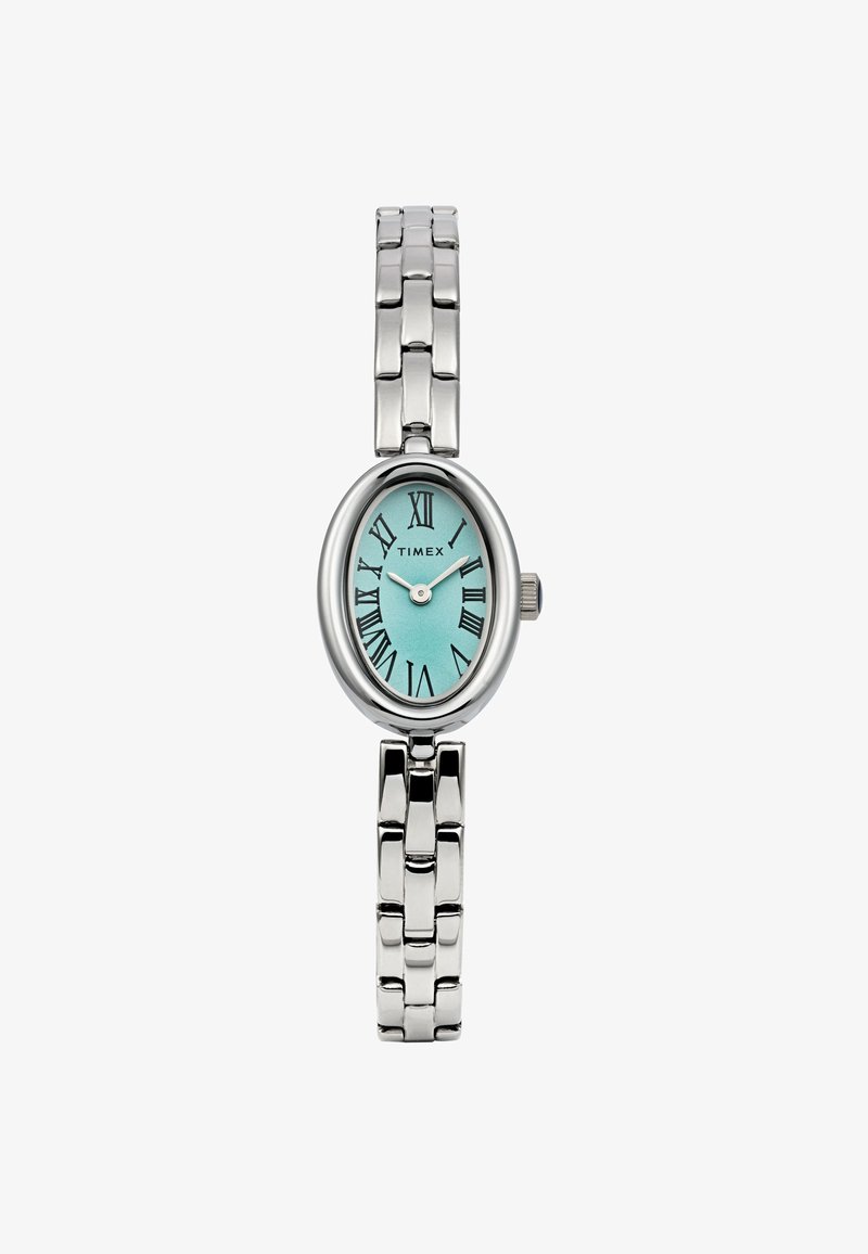 Srebrny zegarek Timex o owalnej tarczy, tealowym cyferblacie, rzymskich cyfrach oraz polerowanej metalowej bransolecie z teksturowanymi ogniwami.